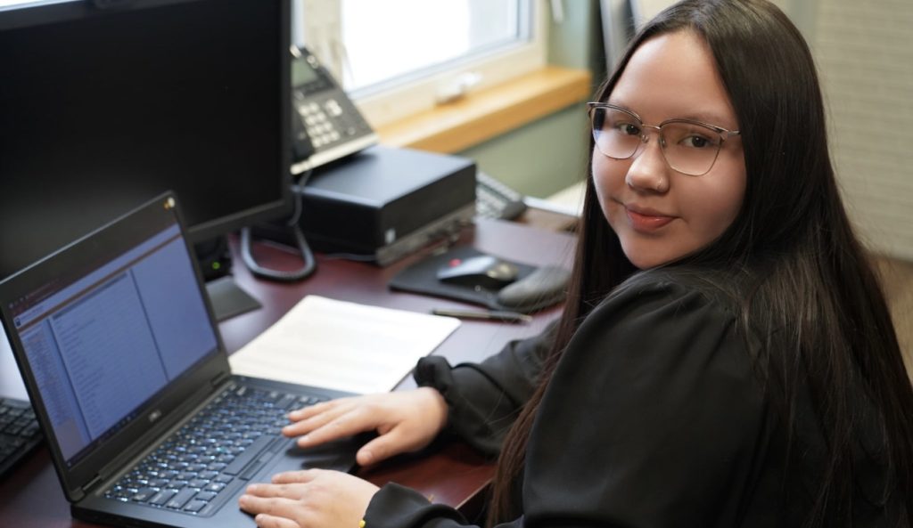 youth sitting at laptop in the office